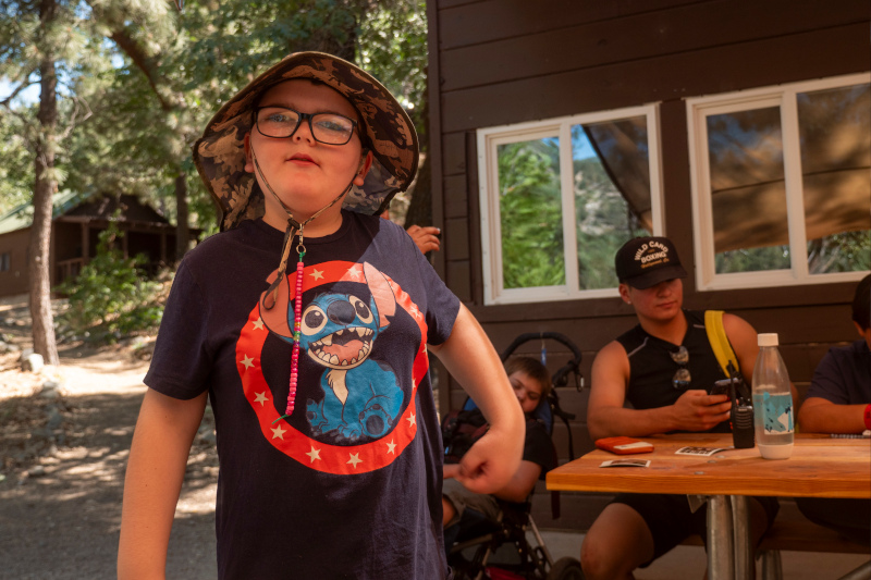 Young camper with down syndrome in a hat at summer camp